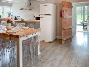 a kitchen with a table with chairs and a refrigerator at Smallbrook Cottage - Uk50922 in Salisbury