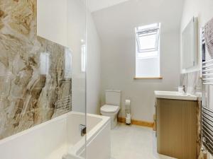 a bathroom with a toilet and a sink at Penshenkin Barn in Llanfihangel-nant-Melan