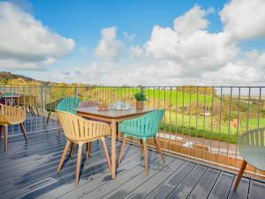 a wooden deck with a table and chairs on a balcony at Foxglove-Uk34612 in Nether Stowey