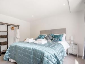 a bedroom with a bed with a blue comforter at Pennyard House in Banwell