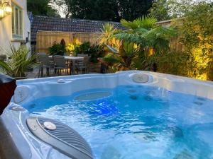 a hot tub in a backyard with a table at Pennyard House in Banwell +23 photos