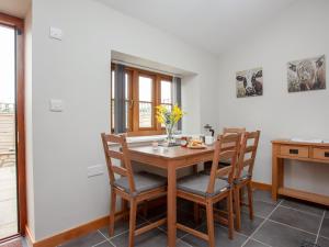 a dining room with a wooden table and chairs at Daisy Cottage - Uk31294 in Locking +15 photos