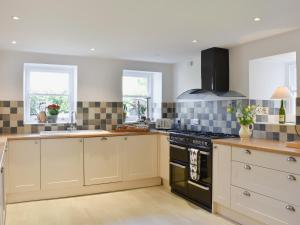 a kitchen with white cabinets and a stove top oven at Brittain House in Richmond +19 photos