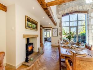 a dining room with a table and a fireplace at Badger Hill Barn in Malham