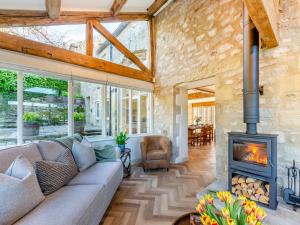 a living room with a couch and a fireplace at Badger Hill Barn in Malham