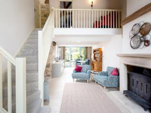 a living room with blue chairs and a fireplace at The Hall - Uk32690 in Horton +5 photos