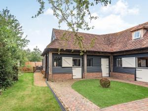 a brick house with white doors and a yard at Silhouette's Stable - Uk34102 in Chichester