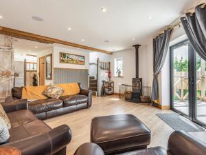 a living room with leather furniture and a fireplace at Silhouette's Stable - Uk34102 in Chichester +19 photos