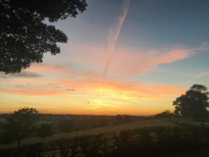 a sunset in a field with a sky at Trezeal Barn in North Hill +8 photos