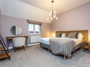 a bedroom with a bed and a mirror and a chair at The Hazels - Ukc4614 in Dunholme