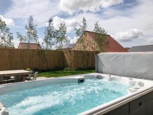 a hot tub in a backyard with a fence at The Hazels - Ukc4614 in Dunholme