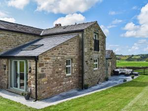 an exterior view of a stone house with grass at Swiss Cottage in Lancaster