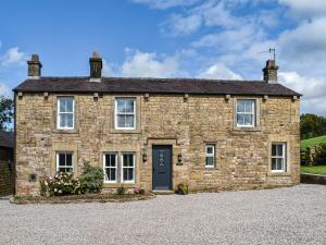a stone house on a gravel driveway at Swiss Cottage in Lancaster