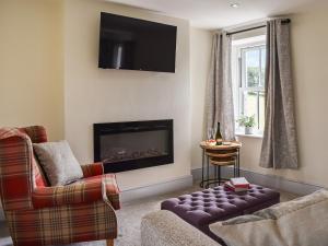 a living room with a couch and a fireplace at Swiss Cottage in Lancaster +18 photos
