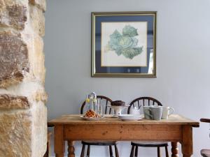 a dining room table with chairs and a picture on the wall at Grapevine Cottage in Stocklinch