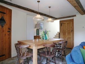 a dining room with a wooden table and chairs at Grapevine Cottage in Stocklinch