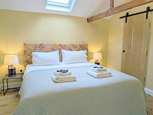 a bedroom with a bed with towels on it at The Stables - Uk50804 in Halesworth +10 photos
