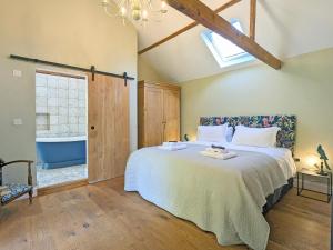 a bedroom with a large bed and a bathroom at The Stables - Uk50804 in Halesworth