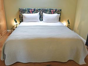 a bedroom with a large white bed with two pillows at The Stables - Uk50804 in Halesworth