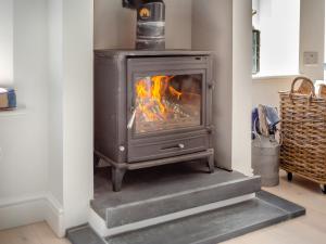 a wood stove in a living room with steps at Tregarrek in Coverack