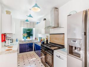 a kitchen with white cabinets and a stove top oven at Tregarrek in Coverack
