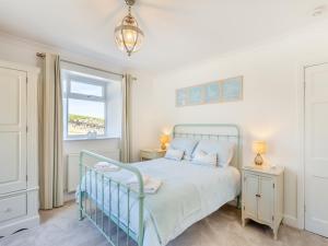a bedroom with a bed and a window at Tregarrek in Coverack +31 photos