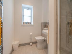 a white bathroom with a toilet and a window at Sandcastles in Bridlington