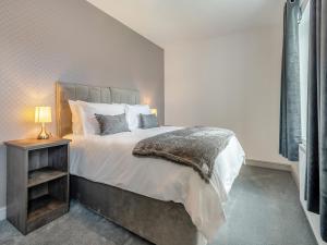a bedroom with a large bed and a night stand at Sandcastles in Bridlington