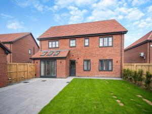 a brick house with a lawn in front of it at Sandcastles in Bridlington +23 photos