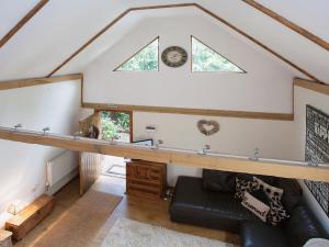 an attic room with a couch and a window at The Barn in Burley