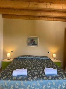 a bedroom with a bed with two towels on it at Locanda Graziella in Moerna