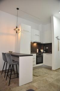 a kitchen with white cabinets and a table and chairs at Studio u srcu Banja Koviljaca in Banja Koviljača