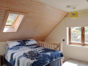 a bed in a room with a wooden ceiling at Seal Rocks in Lendalfoot