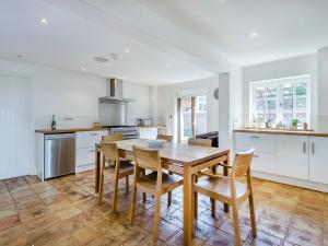 a kitchen with a wooden table and chairs at Wittle Cottage in Quidenham +24 photos