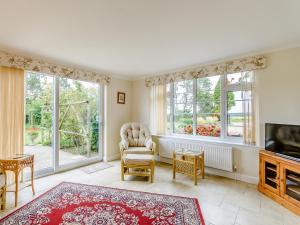 a living room with windows and a chair and a television at Henrys Retreat in Ingoldsby