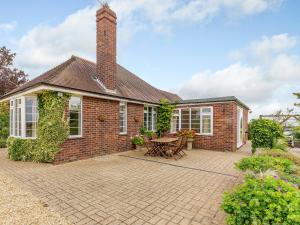 a brick house with a chimney and a patio at Henrys Retreat in Ingoldsby