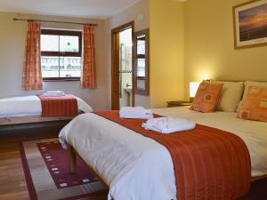 a hotel room with two beds and a window at Eithinog in Talybont
