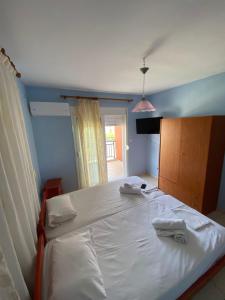 a bedroom with a large white bed with a window at Nelli rooms in Polychrono +2 photos