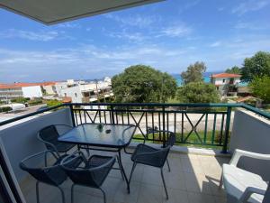 a patio with a table and chairs on a balcony at Nelli rooms in Polychrono