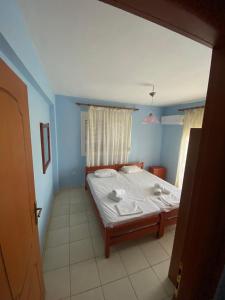 a bedroom with a bed in a blue room at Nelli rooms in Polychrono
