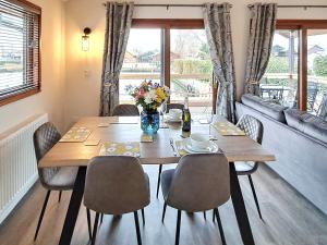 a dining room with a table and chairs and a couch at River Breeze-B6853 in Brundall