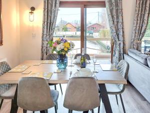 a dining room table with chairs and a vase of flowers at River Breeze-B6853 in Brundall