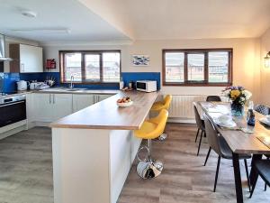 a kitchen with a counter and a table and chairs at River Breeze-B6853 in Brundall