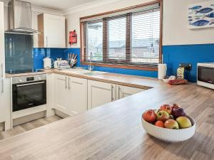 a bowl of apples on a table in a kitchen at River Breeze-B6853 in Brundall +5 photos