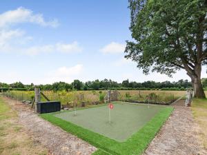a golf course in a field with a tree at The Barn - Uk49371 in Send