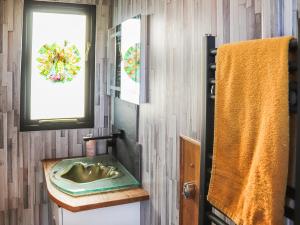 a bathroom with a sink and a window and a towel at The Peacock Roost - Uk46297 in Brynkir