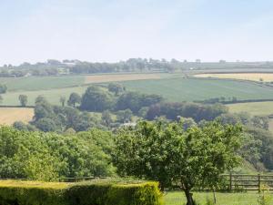 a view of the rolling green fields and trees at Swallows Cottage in Parkham