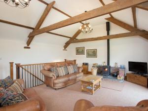 a living room with leather furniture and a fireplace at Swallows Cottage in Parkham +9 photos