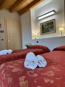 a room with two beds with towels on them at Locanda Graziella in Moerna