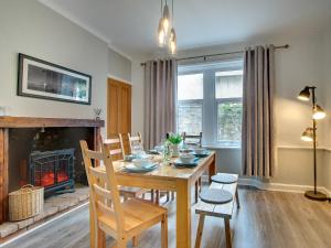 a dining room with a table and a fireplace at Heron House in Tweedmouth